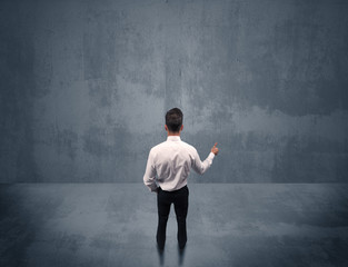 Businessman standing in front of urban wall