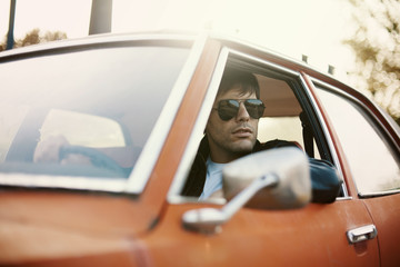 Handsome male model posing in car