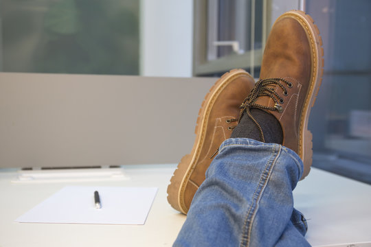 Man relaxing at the office with his feet on the table.
