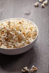 Olive oil popped popcorn in a porcelain bowl angled view