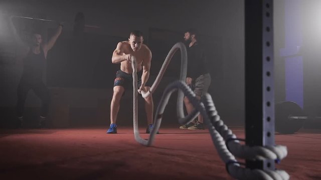 Young athlete doing exercise with rope.