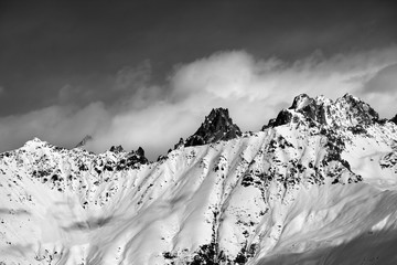 Black and white snow avalanches mountainside in clouds