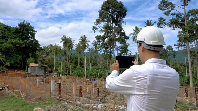 Engineer taking photos of constructuin site on tablet