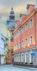 Narrow street with a view on the building of Dome church in old Riga that is the capital of Latvia and famous European city of medieval architecture