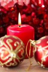 candles on wooden Christmas decorations and red tinsel