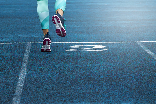 woman running in blue running track
