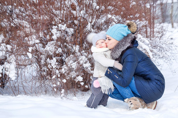 Mother and daughter embrace in the winter.