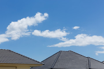 Fototapeta na wymiar black tile roof on house with clear blue sky and cloud