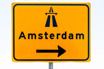 Road sign with an arrow in the direction of Amsterdam