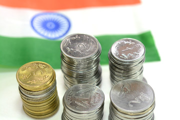 Indian currency coins with the Indian flag in the background.