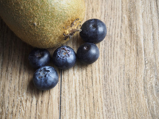 Kiwi and blueberries on wood background