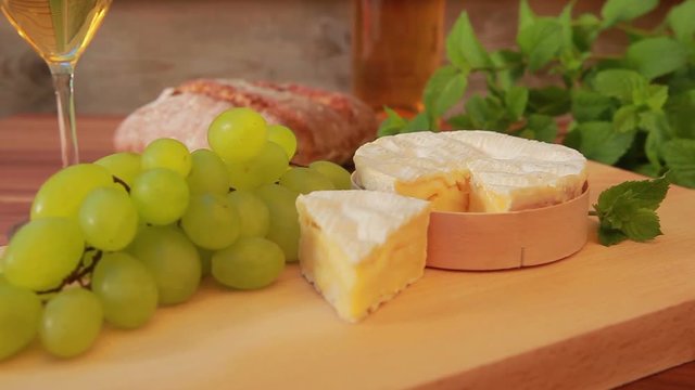 brie cheese with white wine, grapes and bread. Circular movement of the camera