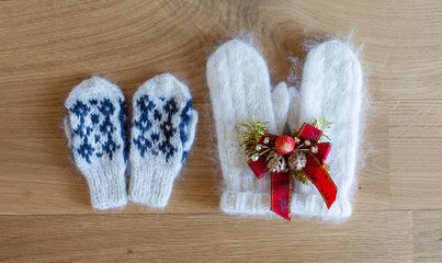 Woman and kids mittens on wooden background
