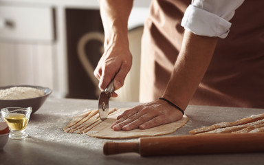 Fototapeta na wymiar Male hands preparing pasta on kitchen table