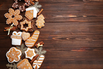 Tasty gingerbread cookies and Christmas decor on wooden background