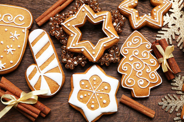 Tasty gingerbread cookies and Christmas decor on wooden background, close up