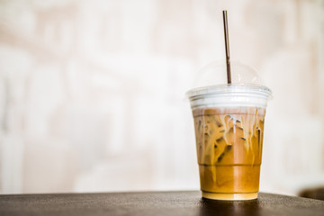 Café con leche con hielo en vaso de plastico con pajita