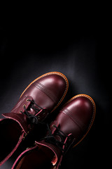 Fashionable mens leather brown shoes on black background. . Men's high boots. Top view. Copy space.