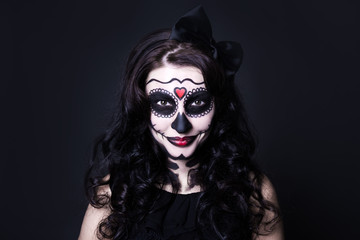 Halloween face art - woman with skull make up over black