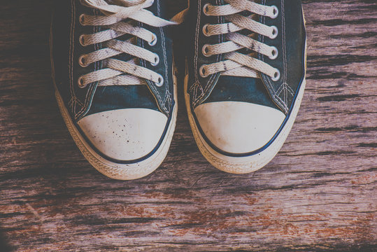 Sneakers on wooden background. Vintage effect.