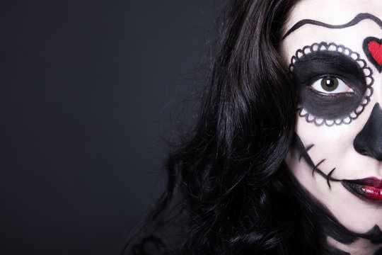 close up portrait of woman with Halloween skull make up over bla