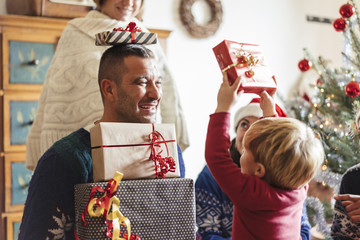 family at home sharing presents for christmas