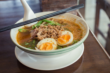 Noodle Tom Yam, hot spicy soup served with boiled egg.