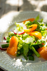 Fresh salad with summer vegetables on the wooden table. Shallow depth of field.