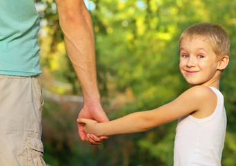 Family Father Man and Son Boy Child holding hand in hand Outdoor Happiness emotion with summer nature on background
