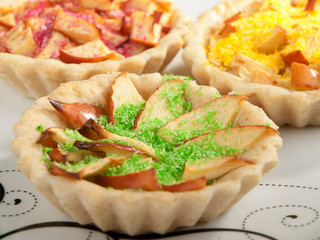 Small apple tartelettes with decoration. Horizontal shot