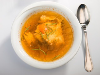 Plate of poached egg soup. Baked bread on background. Shot from