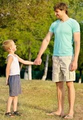 Fototapeta premium Family Father Man and Son Boy Child holding hand in hand Outdoor Happiness emotion with summer nature on background