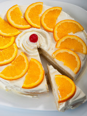 Homemade vanilla cake with heavy cream and orange slices