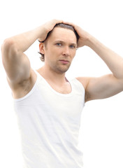 Young Man upsweeping Hair with his muscular arms raised on his Head isolated on white background