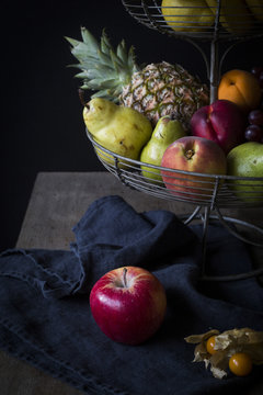 Fresh fruits in metal &eacute;tag&egrave;re before dark background