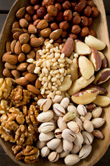 different knds of nuts in a wooden plate