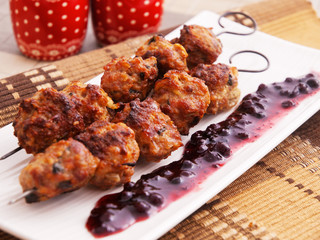 Lamb meatballs baked on skewers with cranberry sauce