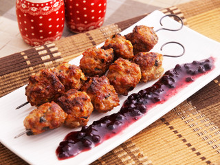 Lamb meatballs baked on skewers with cranberry sauce
