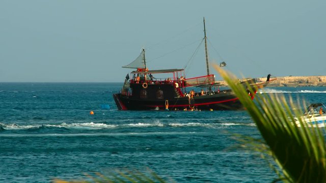 Old Sailing Ship. View through the tops of the palm trees