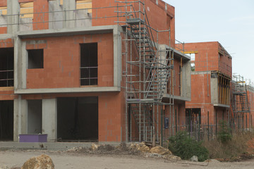 Building and cranes under construction against blue sky