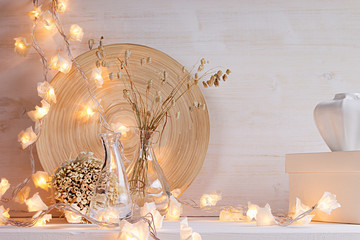 Christmas home decoration with lights on  white wooden background. Interior.