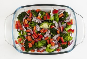 Vegetable salad in a glass dish on a white background