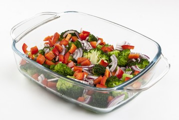 Vegetable salad in a glass dish on a white background