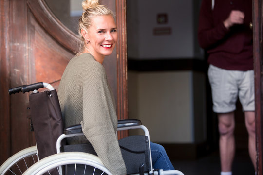 woman in wheelchair in front of entrance door