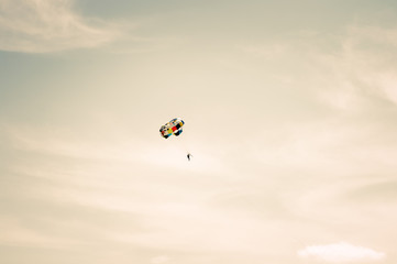 Naklejka na ściany i meble Parachuting extreme Sport with cloudy sky on background Summer Travel Lifestyle and Freedom concept soft light sunset colors