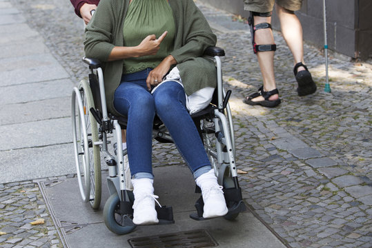 woman in wheelchair pointing to another disabled person