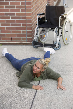 woman lying on floor next to wheelchair