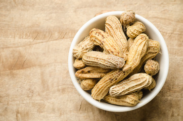 Boiled peanuts or groundnuts in a bowl on wooden background 