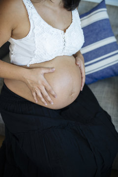 Pregnant holds her tummy.