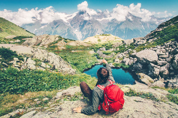 Fototapeta premium Traveler Man with backpack relaxing hand showing destination Travel Lifestyle concept serene view mountains and clouds landscape on background summer vacations outdoor